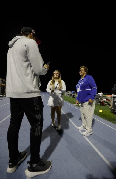 Hi’s Eye Sports reporter Emerson Wotanowski on the sidelines of a football game with Athletic Director Sandra Mamary