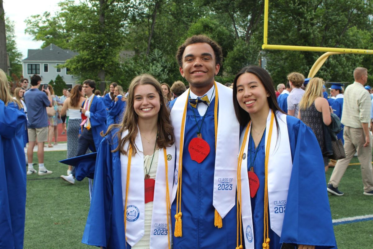 From left to right: Sophie Latessa, Sean Henderson and Katherine Li wearing their apples at WHS graduation 2023